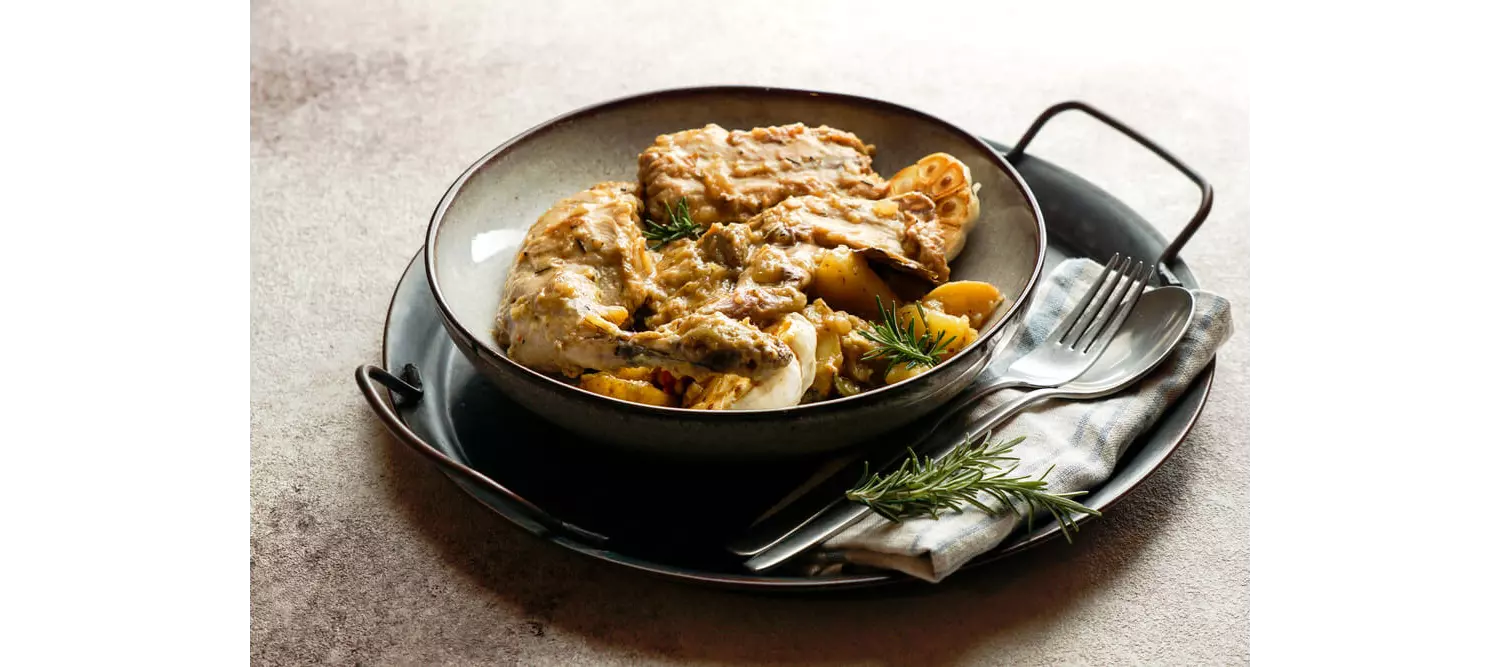 Conejo en Salmorejo: A plate of rabbit thighs covered in a sauce