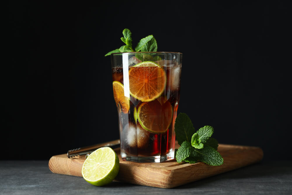 Cuba Libre: Close-up of a Cuba Libre cocktail with lime and mint leaves