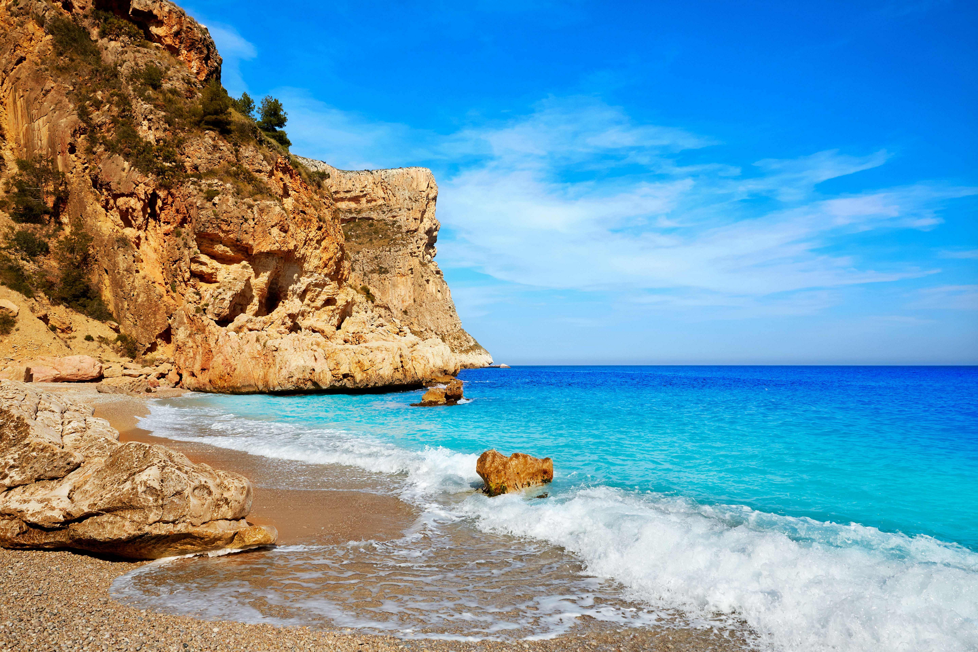 Costa Blanca Best Beaches: Topaz sea lapping against a golden shore, surrounded by cliffs