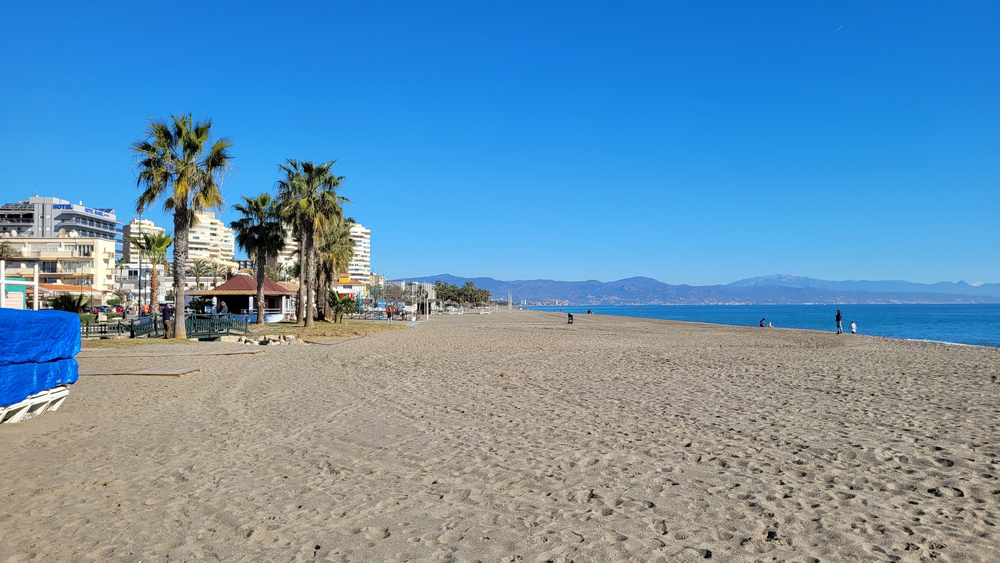Torremolinos: A white sand beach lined by buildings and mountains