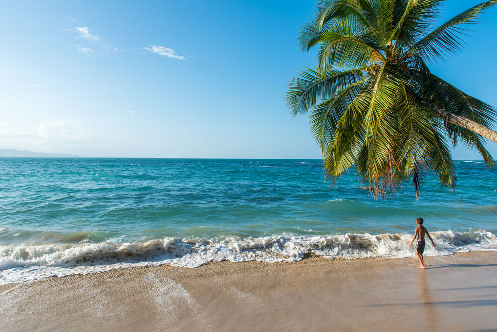 Kind an einem paradiesischen Tropenstrand in Costa Rica.