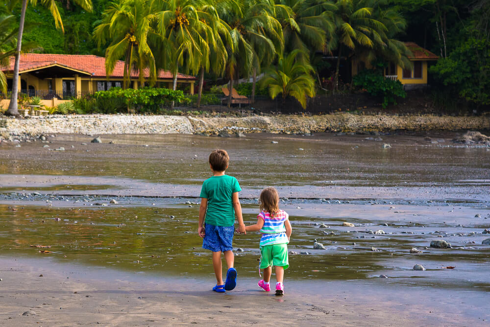 Costa Rica mit Kindern: zwei kleine Kinder gehen am Strand spazieren.