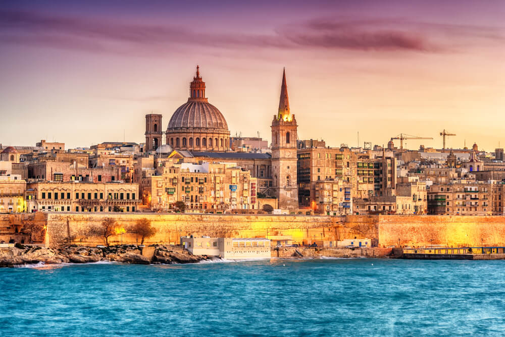 The Valletta skyline and old city walls next to the sea