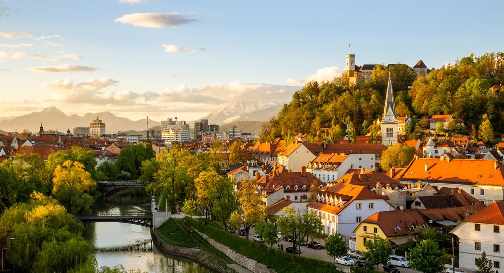 Cyber Monday travel deals: A river surrounded by trees and the city of Ljubljana