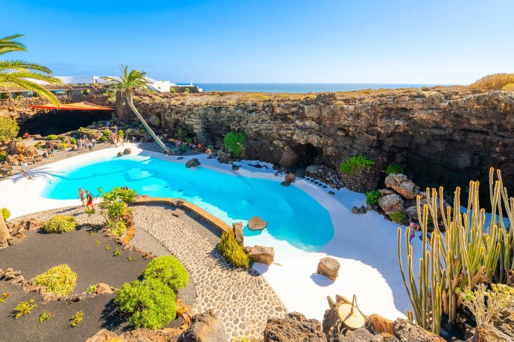 César Manrique: A white floor and blue pool surrounded by volcanic rock