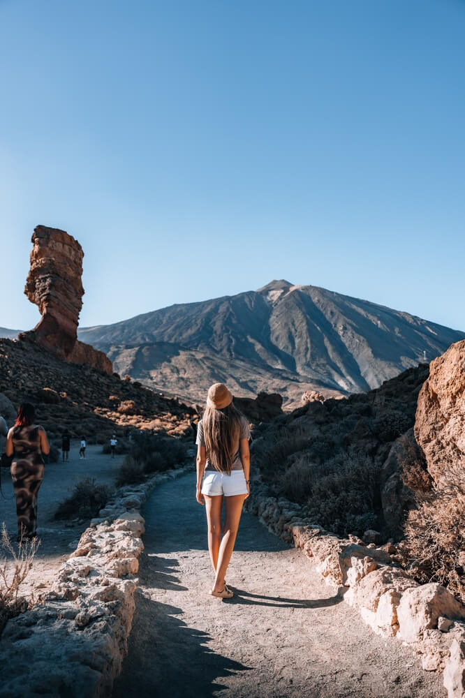 El Teide: A woman walking down a dirt track towards a volcano