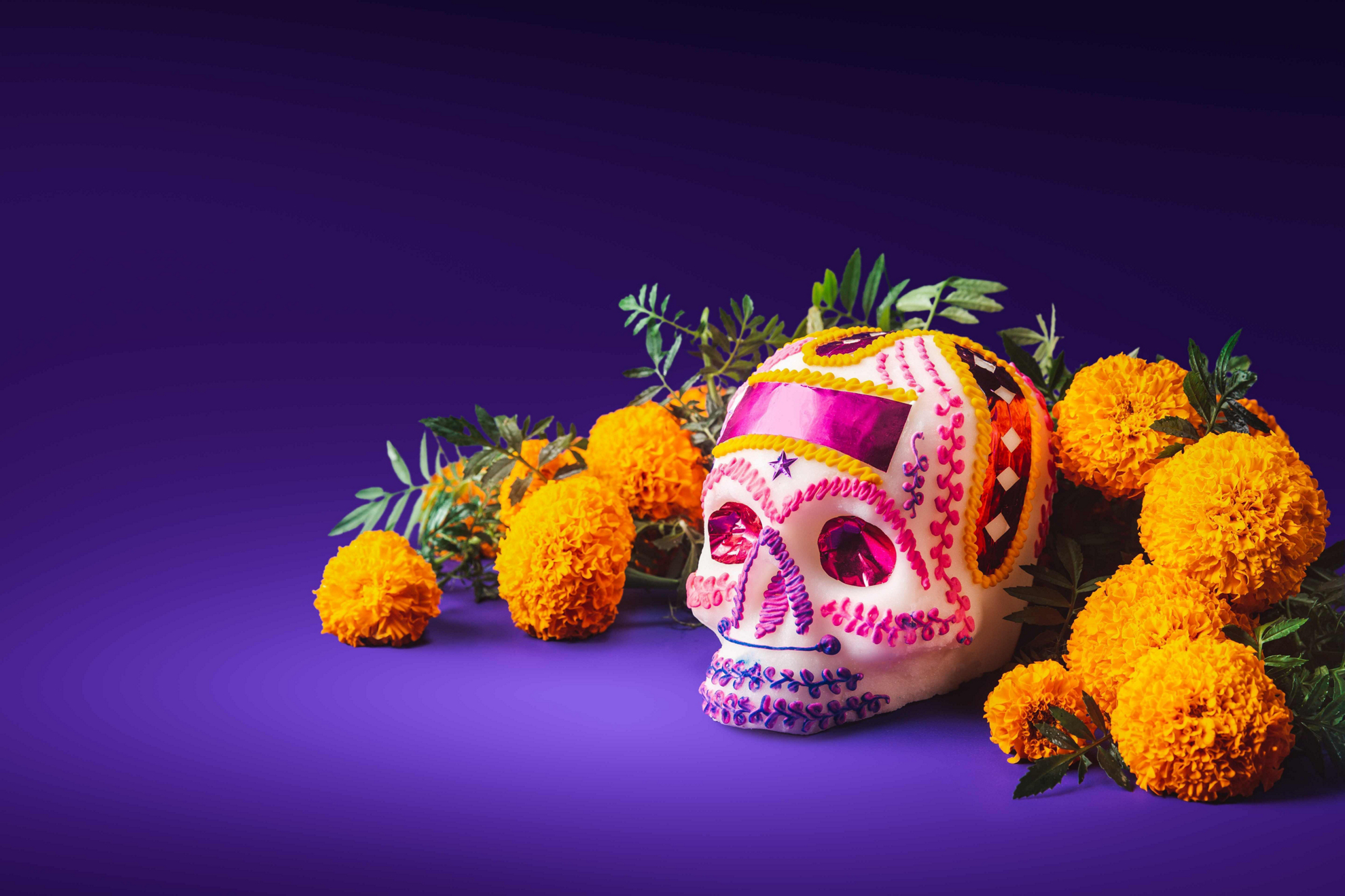 Tag der Toten in Mexiko: Typischer Zuckerschädel mit Studentenblumen (cempasúchil).
