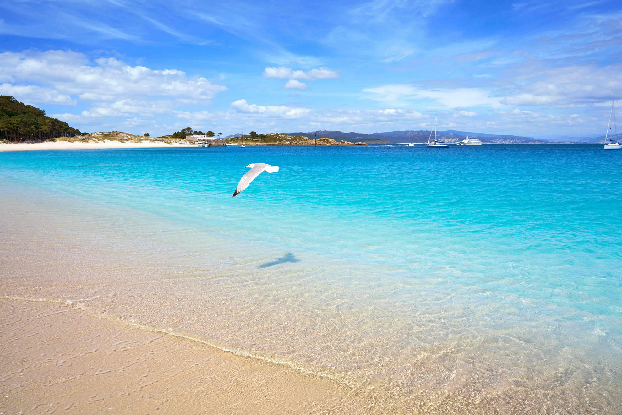 Die schönsten Strände Spaniens: typischer weißer Sandstrand mit türkisblauem Wasser.