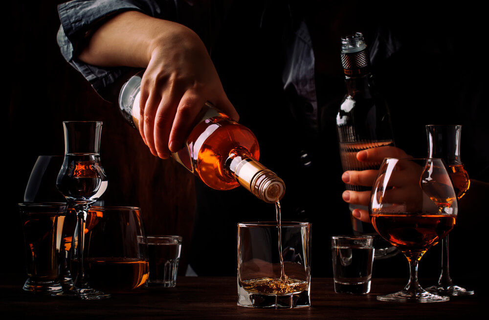 Dominican rum: Man pouring a bottle of rum into a glass