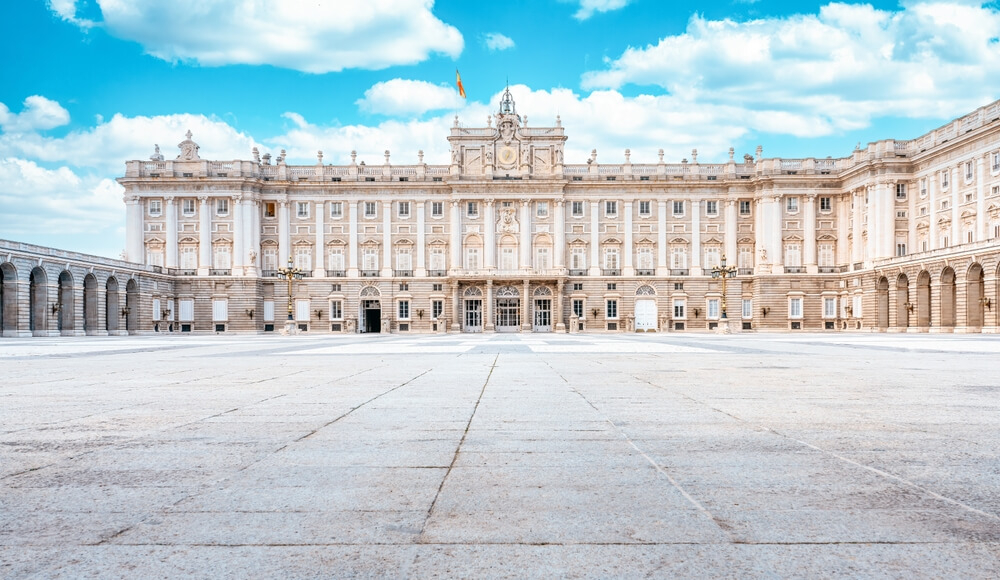 Royal Palace: A large white stone majestic building with a wide open white stone patio