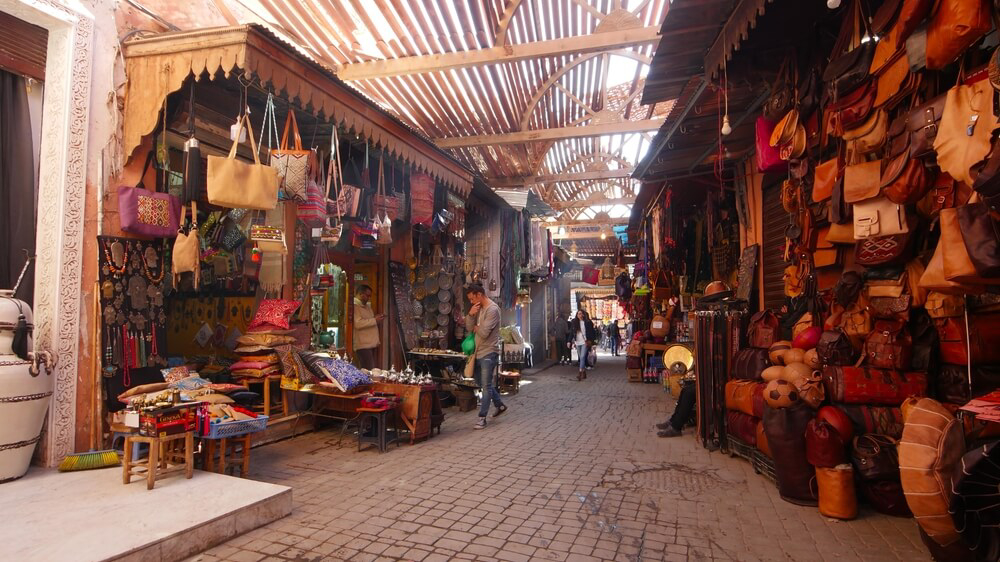 Souk Marrakech: A snapshot of a busy street inside the souk of Marrakech with shoppers visiting stalls