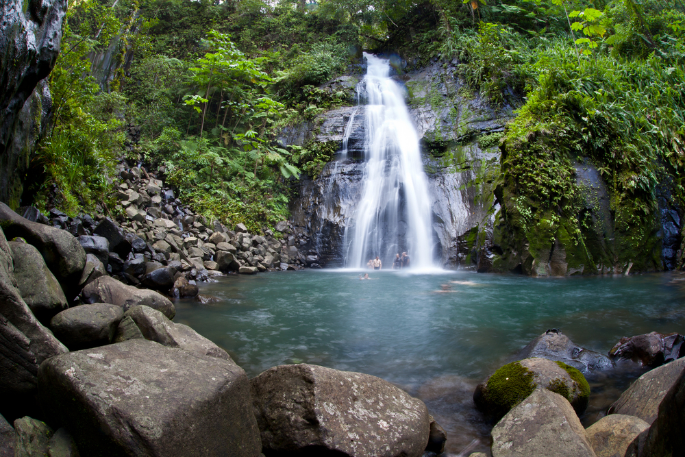 Menschen baden an einem Wasserfall auf der Isla del Coco.