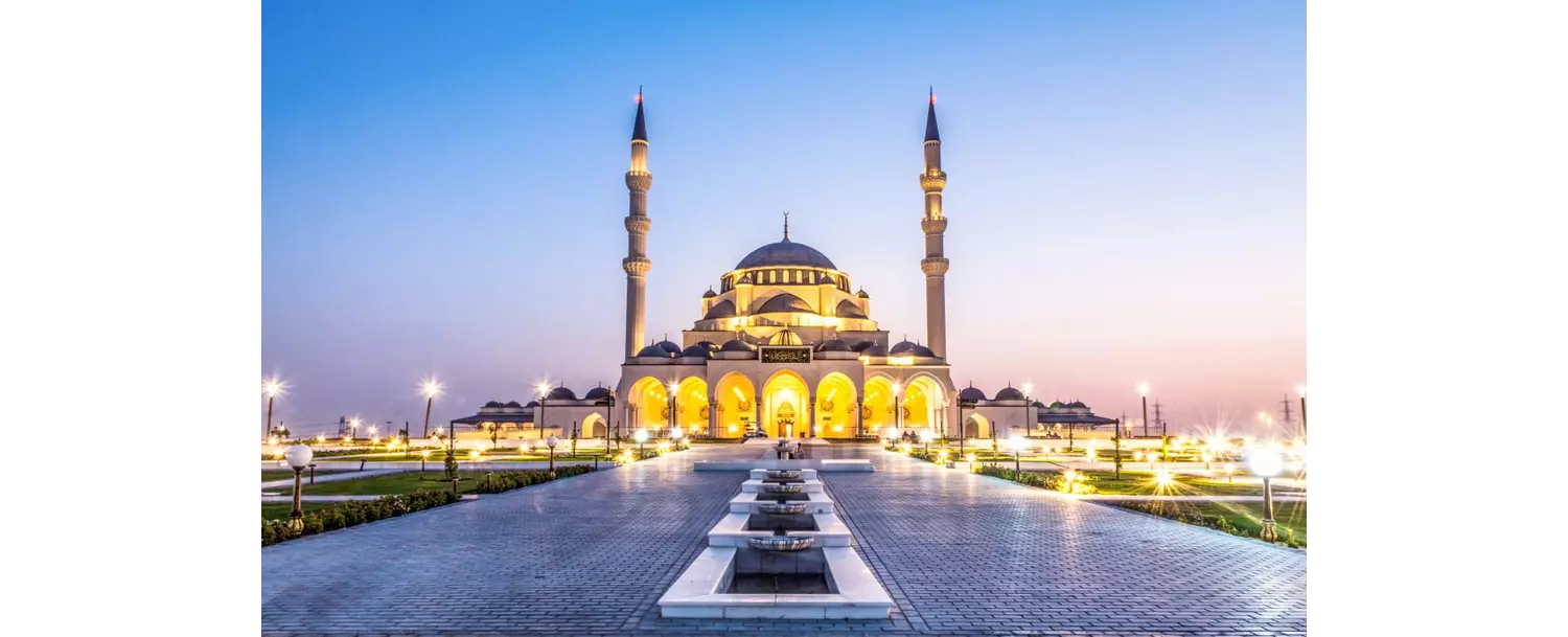 Emirat Sharjah: Blick aus der Ferne auf beleuchtete Moschee.