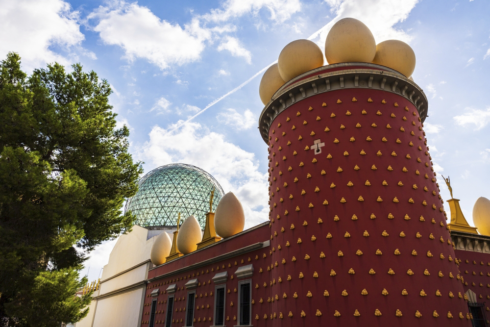 Red facade of the Dalí Theatre-Museum topped with the famous eggs in Figueres