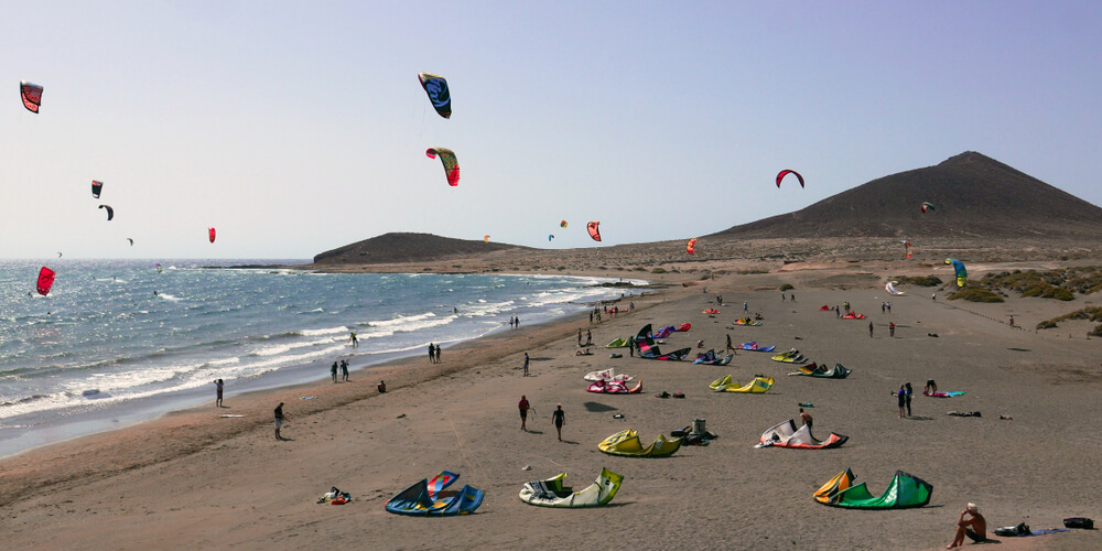 Family beach holidays: Panoramic views of El Medano beach, Tenerife with kitesurfers