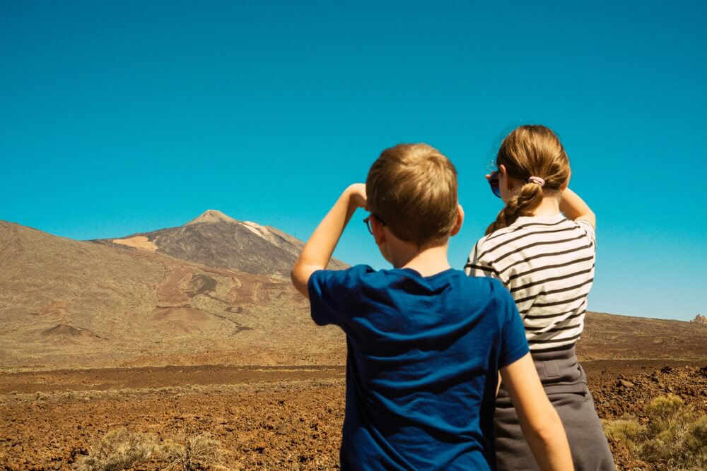 Family hiking holidays: Two children looking at El Teide volcano from a distance