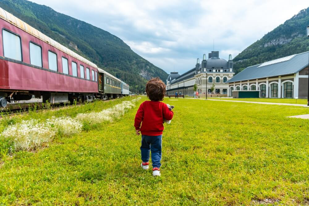 Canfranc: A tiny boy in a red jumper in front of the Barceló Canfranc Estación, a Royal Hideaway Hotel