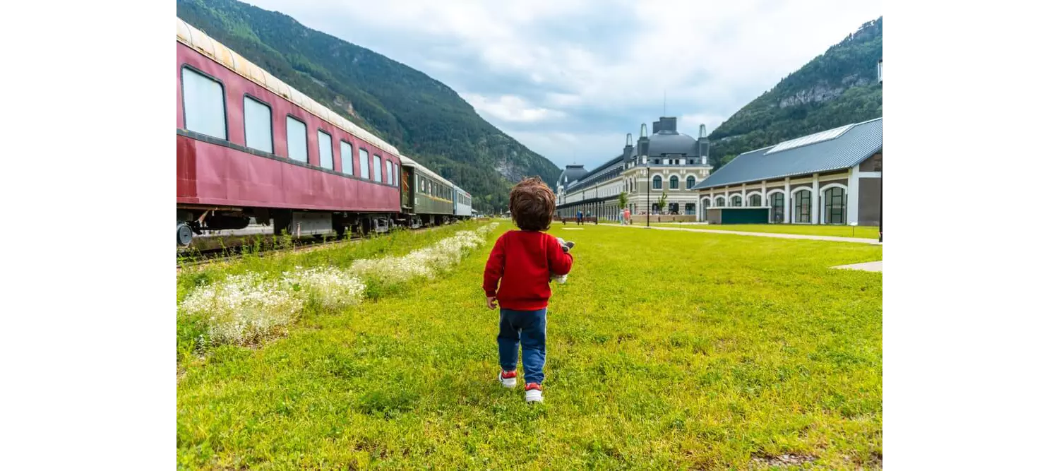 Canfranc: A tiny boy in a red jumper in front of the Barceló Canfranc Estación, a Royal Hideaway Hotel