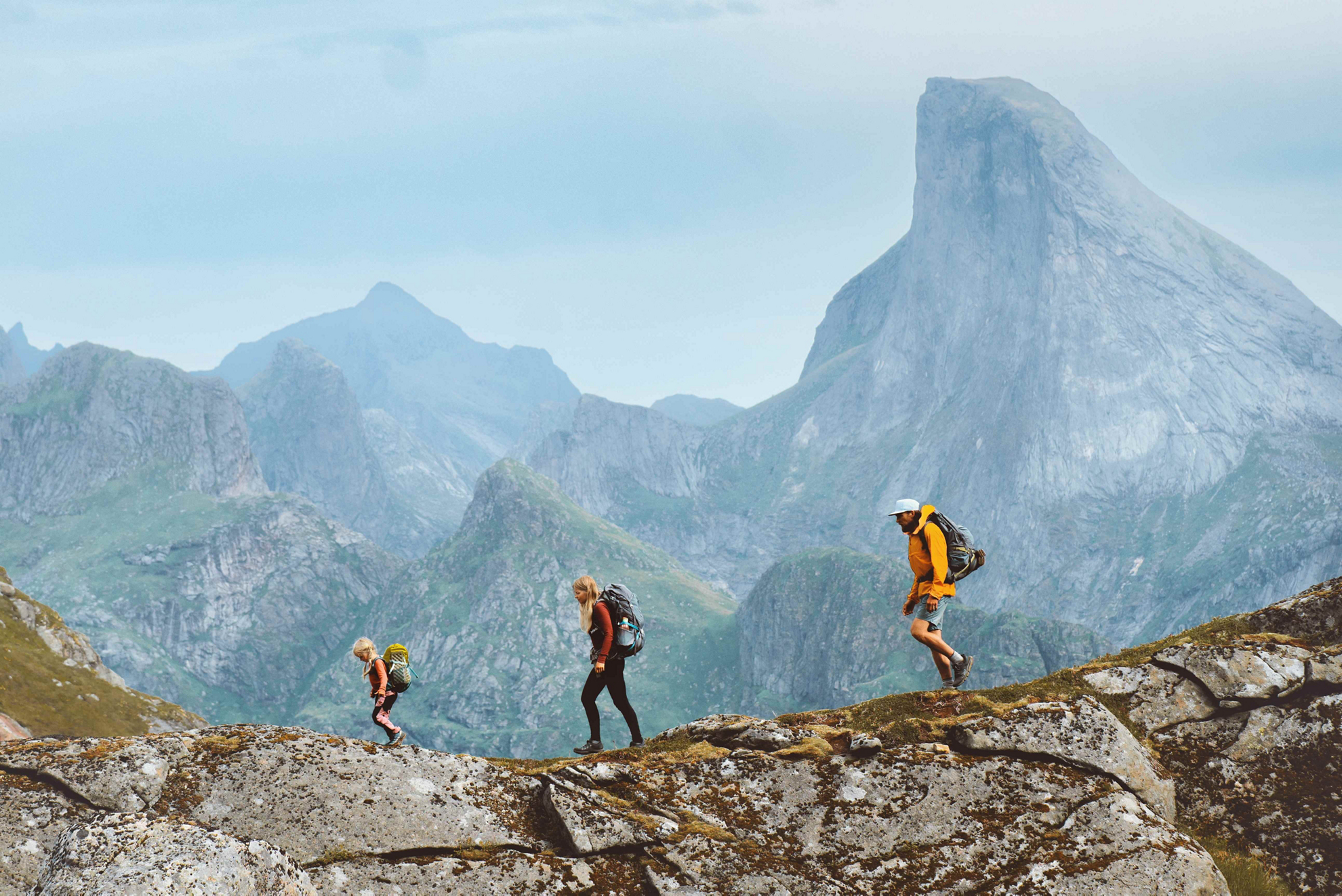 Family hiking holidays: A man, woman and child walking across a mountain