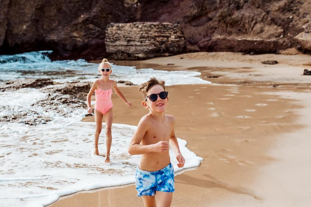 Family holidays in Lanzarote: Two children playing on the golden sand beach