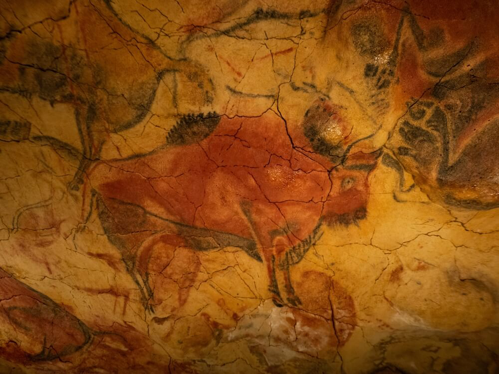 Famous Archaeological Sites: A red stone cave wall covered in cave paintings
