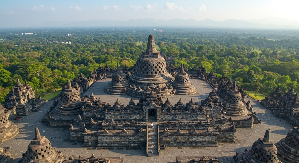 Borobudur: A large stone temple with ornate detail in the forest