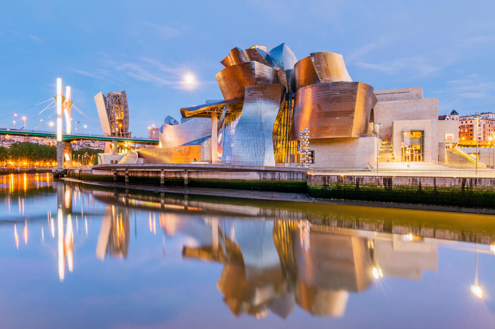 Guggenheim Bilbao: A waterfront view of the Guggenheim Bilbao at sundown