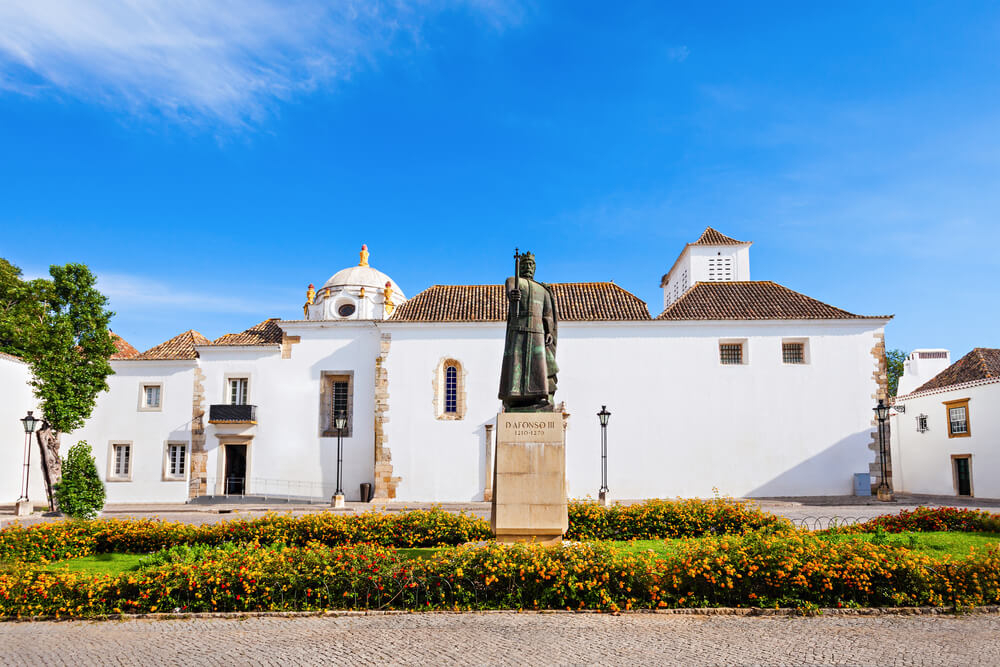 Stadtmuseum von Faro in einem alten Kloster mit einer Statue von Alfonso III im Vordergrund.