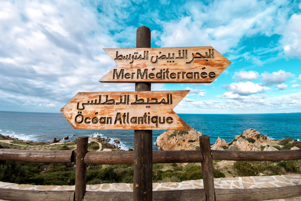 Sailing from Spain to Morocco: A close-up of two wooden signs on the Tangier beach promenade