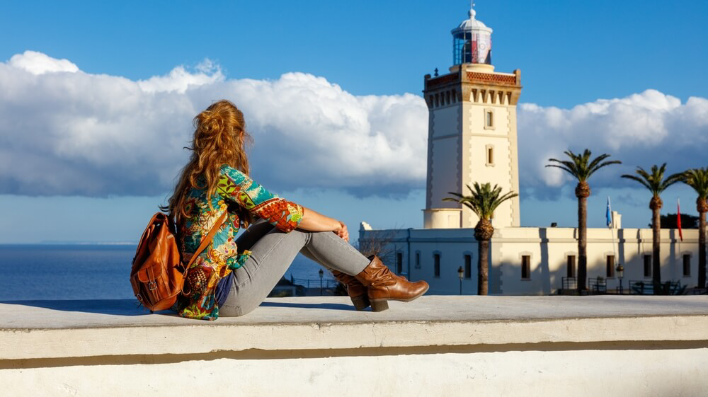 Ferry to Tangier: Woman sat on a wall overlooking the port of Tangier