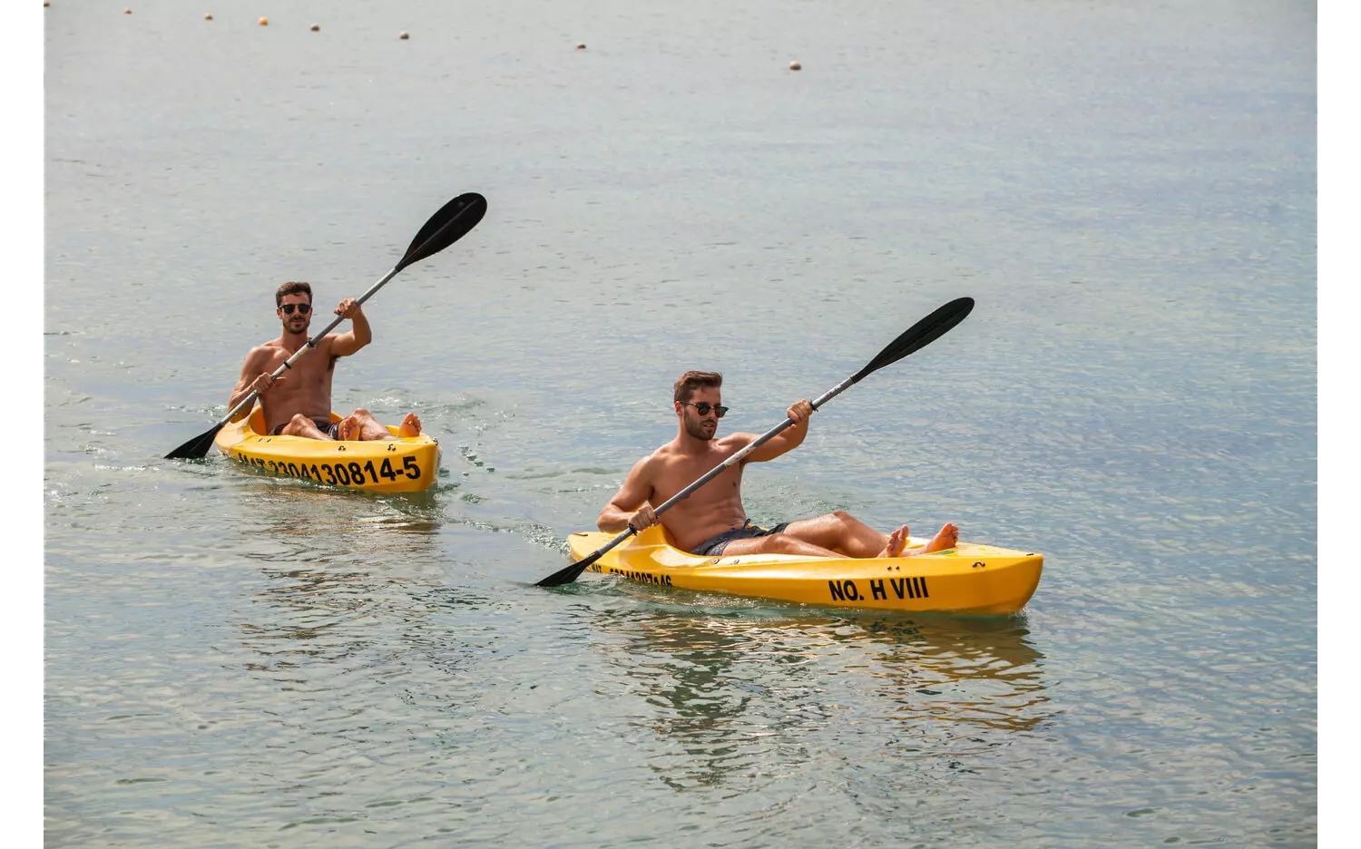 Two men kayaking during a fitness vacation.