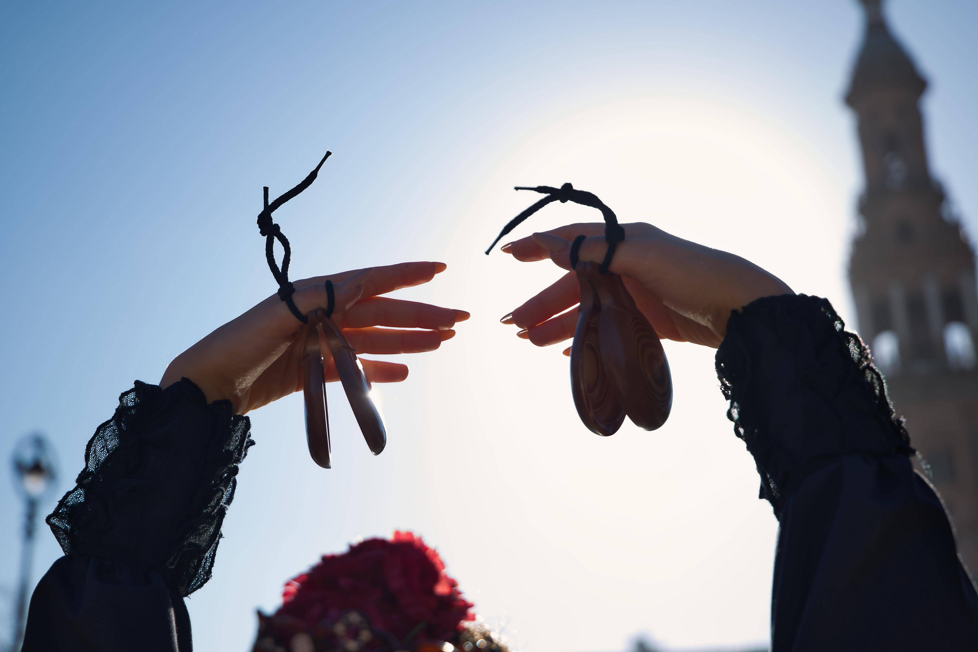 Flamenco shows in Madrid: a woman holding castanets in her hands above her head