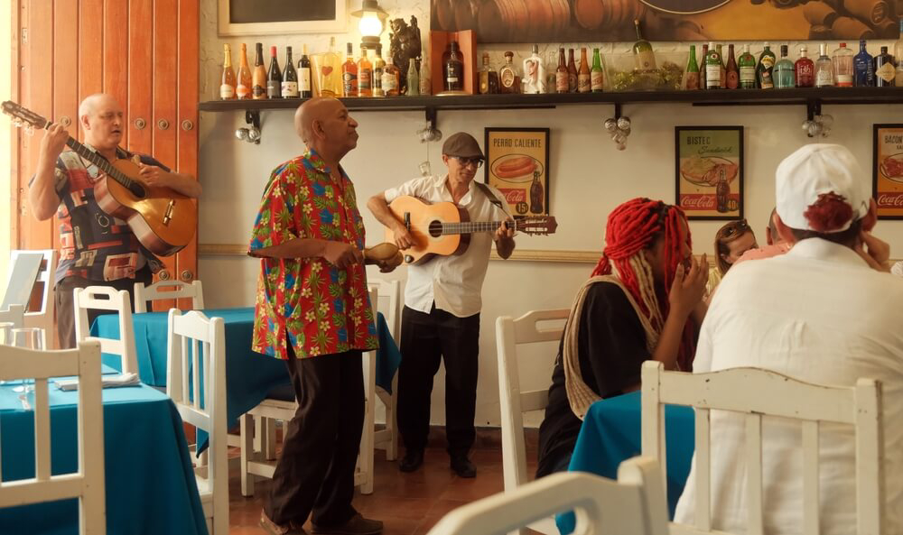 Paladar: Men singing and playing the guitar in a simple restaurant