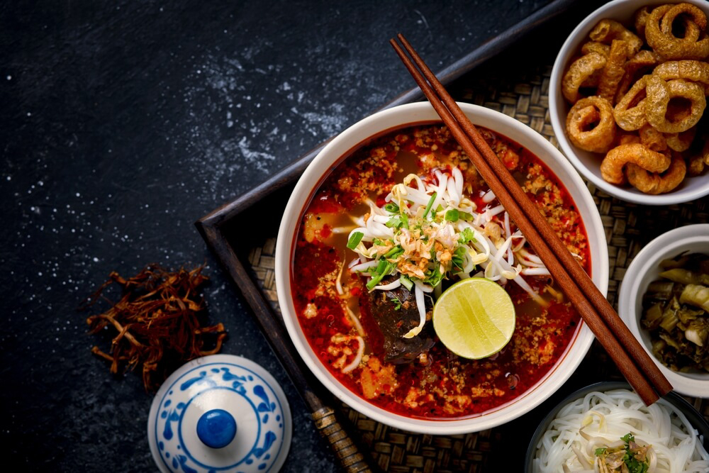 Food in Thailand: A bowl of red spicy stew with chopsticks in a restaurant