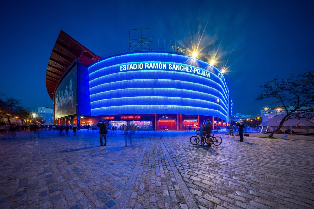 Seville: The Ramón Sánchez Pizjuán stadium lit up at night with blue lights
