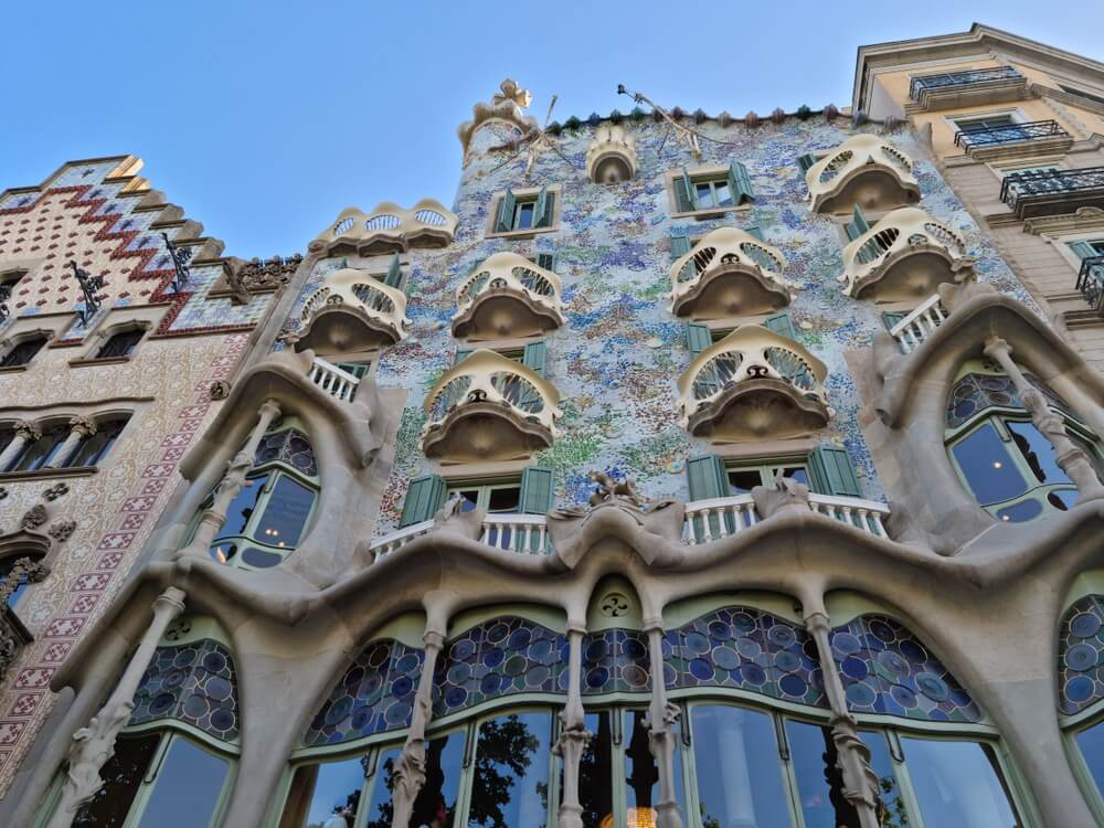 Casa Batlló: Wavy stone building with blue mosaic details