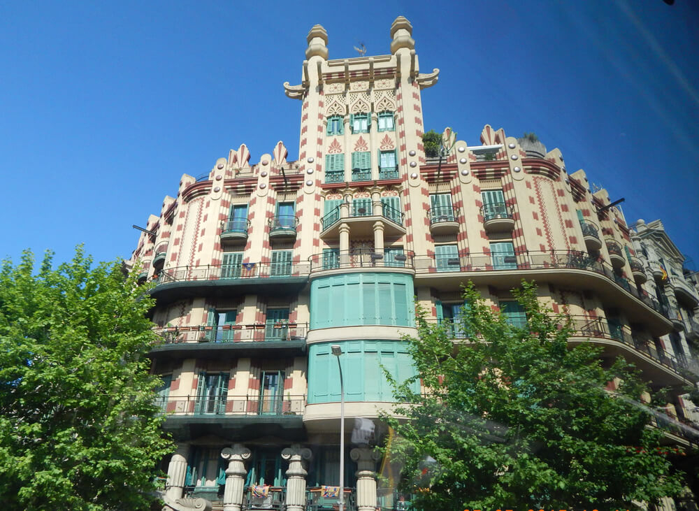 Casa Milà: Tall tower block building with turrets and red stone details