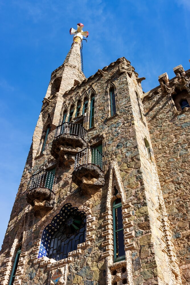 Torre Bellesguard: A tall stone tower with elaborate windows and mosaics