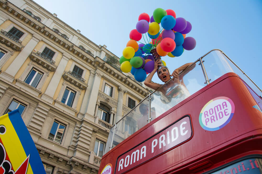 Gay Pride Parades: Woman dancing on a bus in the streets of Rome