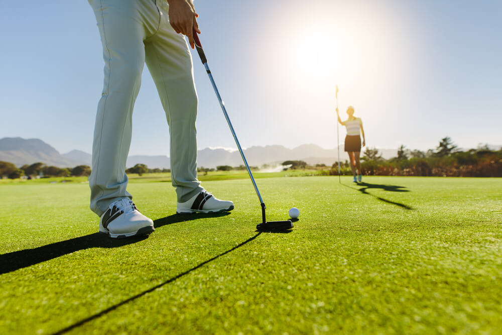 Golf breaks: A close-up of a golf club and a golf ball on a golf course