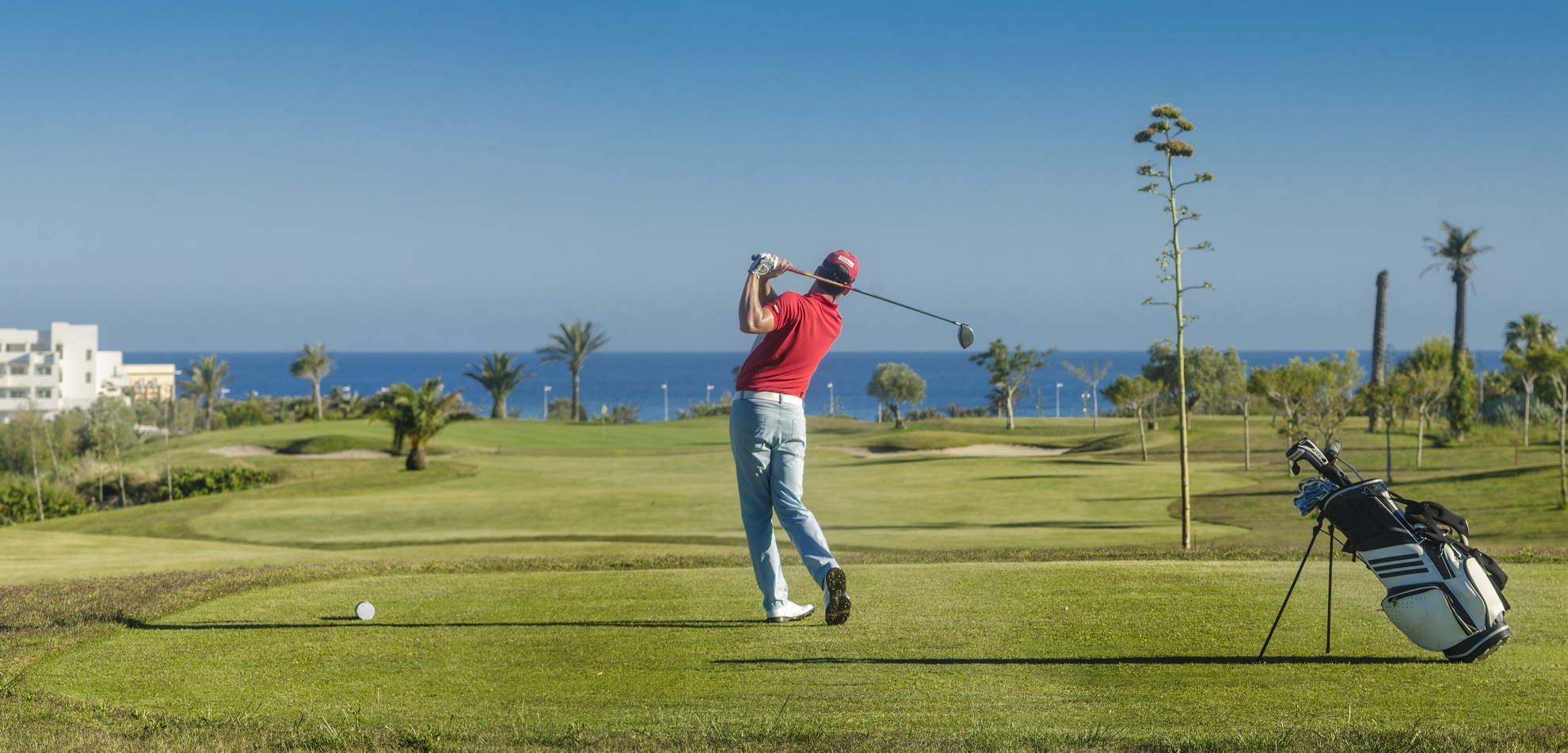 Man dressed in red and white playing golf in the Cabo de Gata