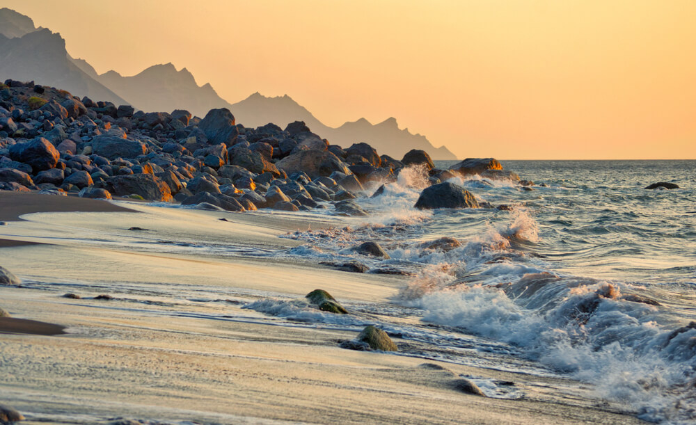 Sonnenuntergang am steinigen Strand von Guayedra auf Gran Canaria.