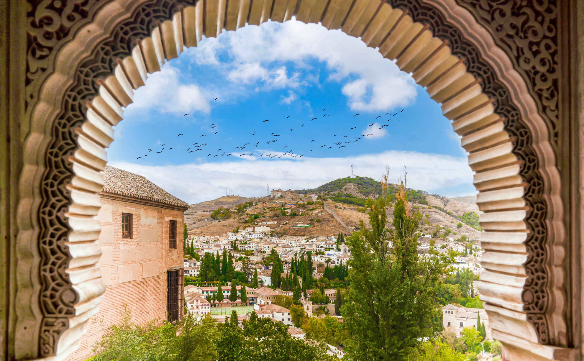 Blick durch einen Hufeisenbogen in Granada, Spanien.