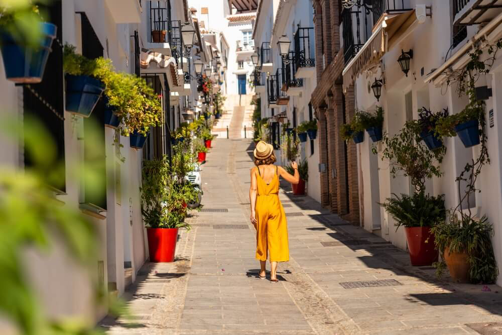 Happy Place: A woman walking along a whitewashed street in Andalusia