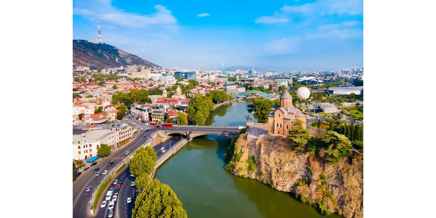 Holidays to Georgia: A view of a river flowing through a city connected by a bridge