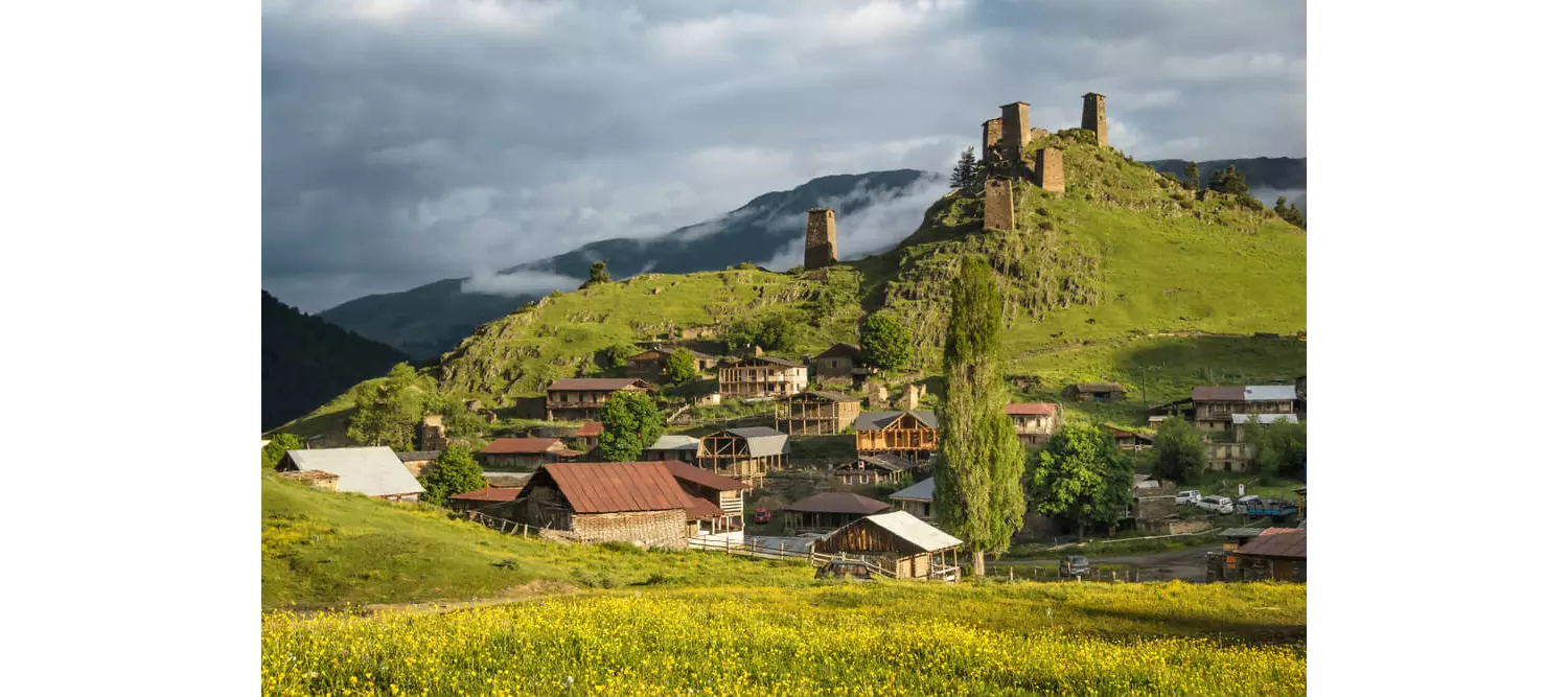 Tusheti: A green hillside dotted with red brick buildings 