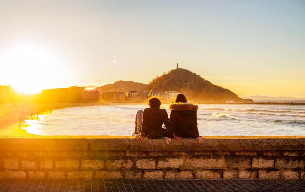 A couple watches the sunset on their honeymoon in northern Spain.