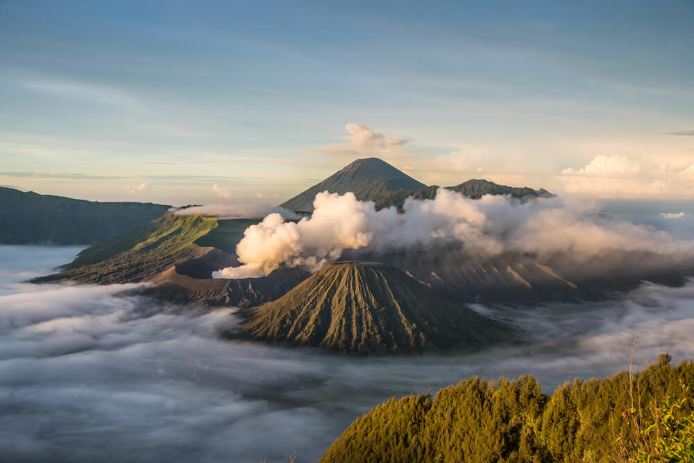 Insel Java: Landschaft mit mehreren Vulkanen in den Wolken.