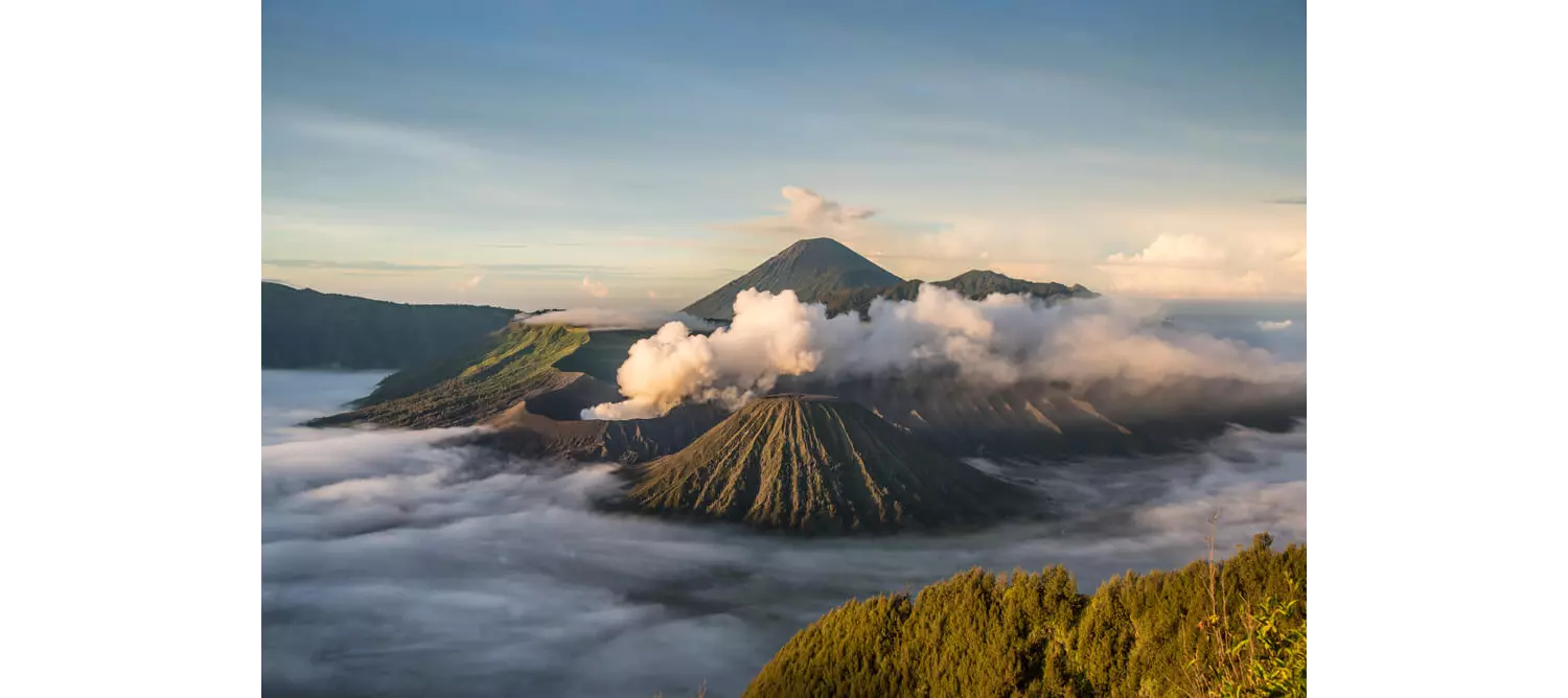 Insel Java: Landschaft mit mehreren Vulkanen in den Wolken.