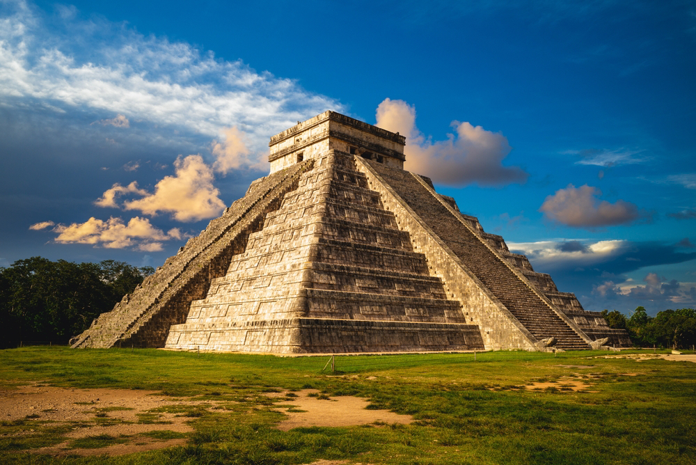 Chichén Itzá: The Temple of Kukulcán surrounded by grass and blue sky